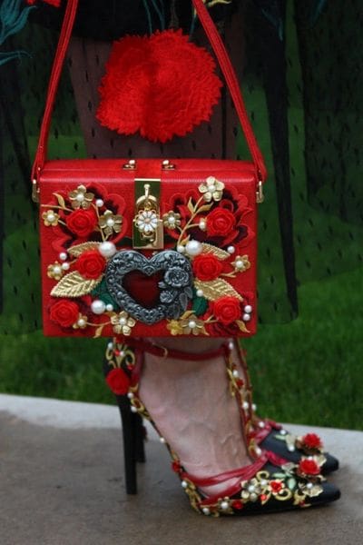 A red purse with flowers and gold accents.