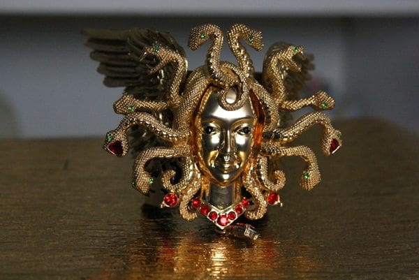 A gold statue with red jewels on top of it.