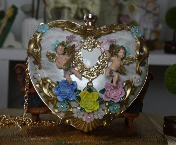 A heart shaped purse with two angels on it.