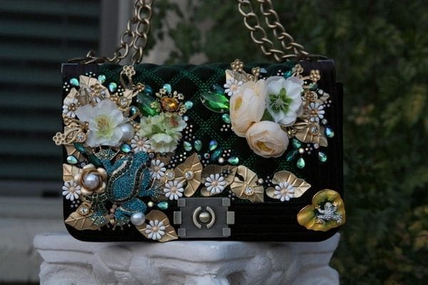 A black purse with flowers and pearls on it