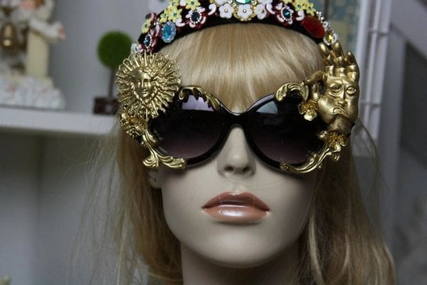 A mannequin wearing sunglasses and a crown.