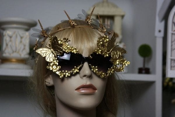 A mannequin wearing gold sunglasses with butterflies on them.