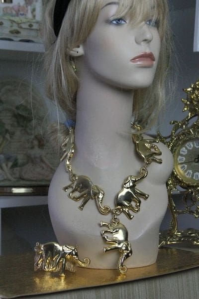 A mannequin wearing a necklace with elephants on it.