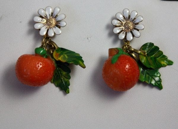 A pair of earrings with orange and white flowers.