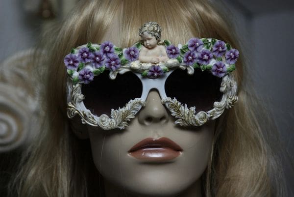 A mannequin wearing sunglasses with purple flowers on them.