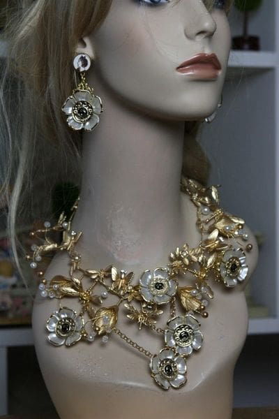 A mannequin wearing a necklace and earrings.