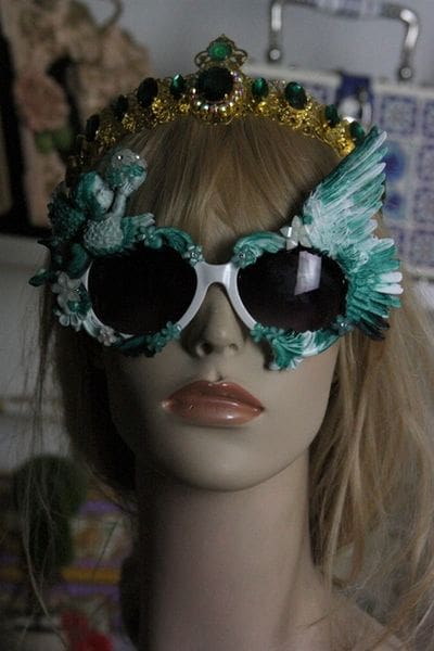 A mannequin wearing sunglasses and a crown.