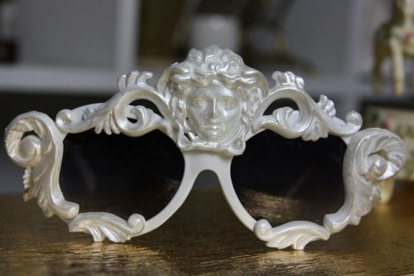 A pair of white sunglasses with a face on them.