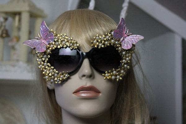 A mannequin wearing sunglasses with butterflies on them.
