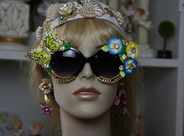 A mannequin wearing sunglasses and headdress with flowers.