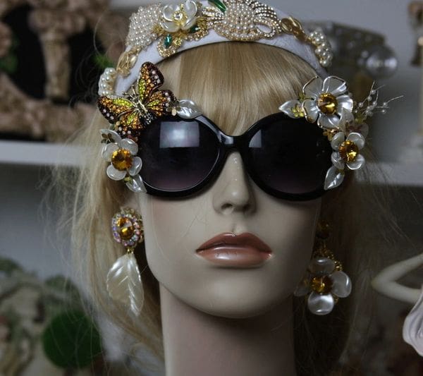 A mannequin wearing sunglasses and headpiece with butterflies.