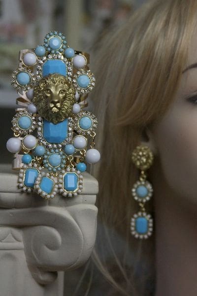 A woman wearing a blue and white earring.
