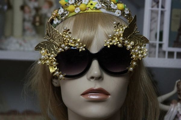 A mannequin wearing sunglasses and a crown.