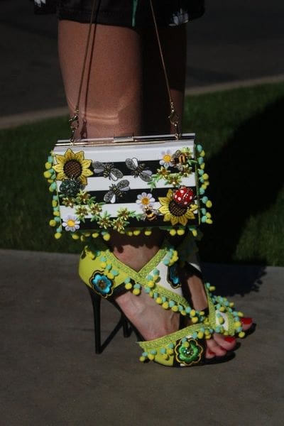 A person wearing high heels and holding onto a purse
