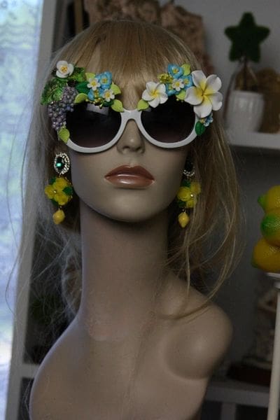 A mannequin wearing sunglasses and earrings with flowers.
