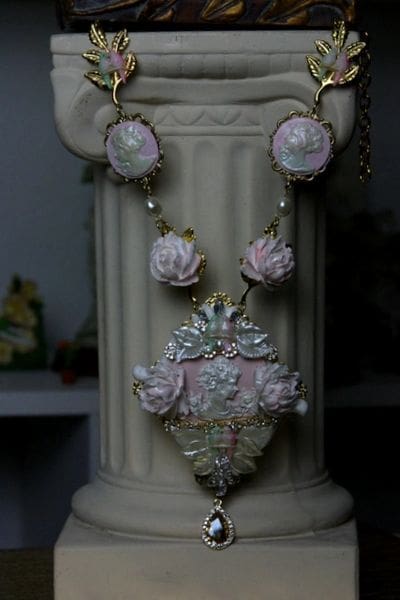 A necklace with pink flowers and pearls on it.