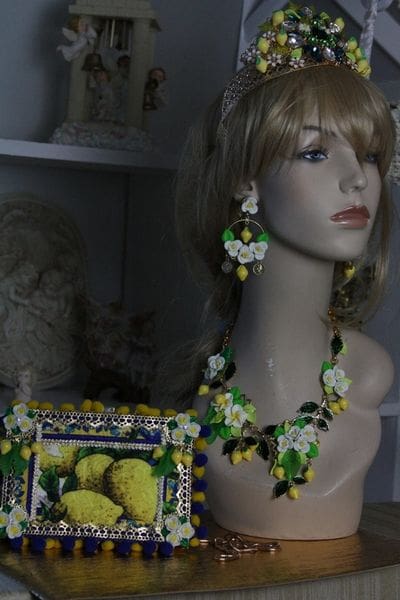 A mannequin wearing jewelry and a basket of lemons.