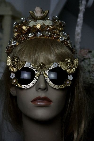 A mannequin wearing sunglasses and a crown.
