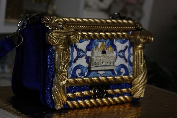 A blue and gold purse with a picture of a castle.