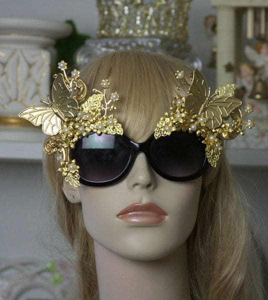 A mannequin wearing gold sunglasses with butterflies on them.