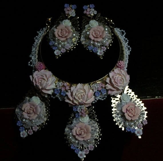 A necklace and earrings set with pink roses.