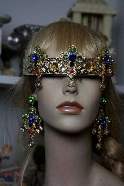 A woman wearing a crown and earrings.