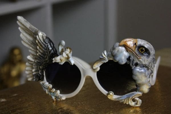 A pair of sunglasses with wings and birds on them.
