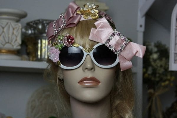 A mannequin wearing sunglasses and a pink bow headband.
