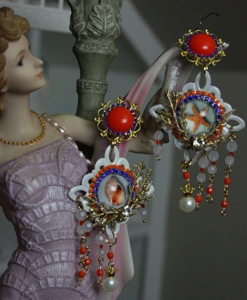 A woman in a dress and necklace holding onto some earrings