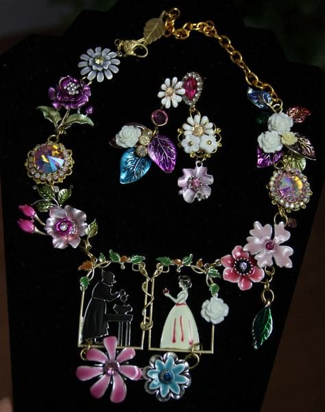 A necklace and earrings set with flowers on it.