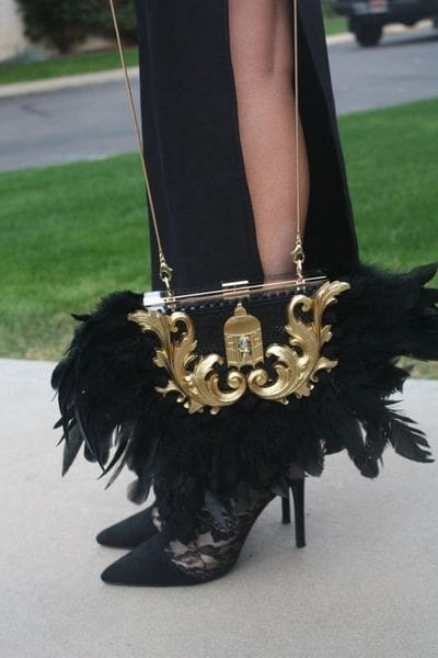 A woman in black dress holding onto a purse