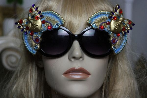 A mannequin wearing sunglasses with blue and gold embellishments.