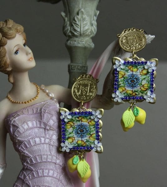 A woman in pink dress and earrings on top of statue.