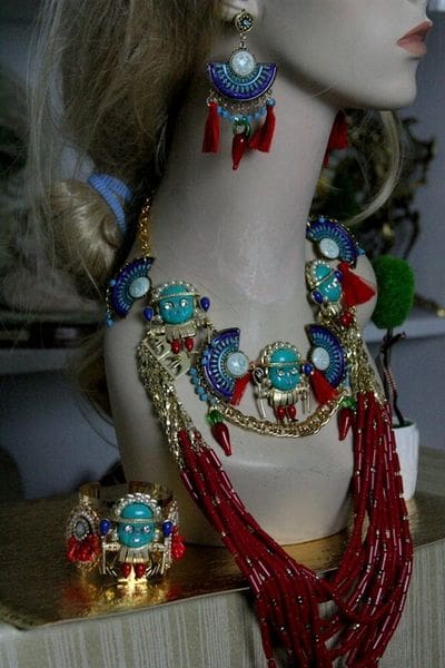 A necklace and earrings set with red, blue and gold beads.