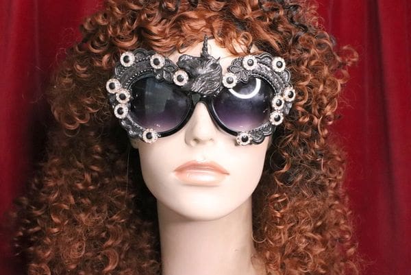 A woman with curly hair wearing sunglasses.