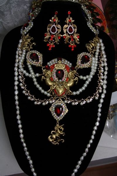 A necklace with pearls and red stones on it