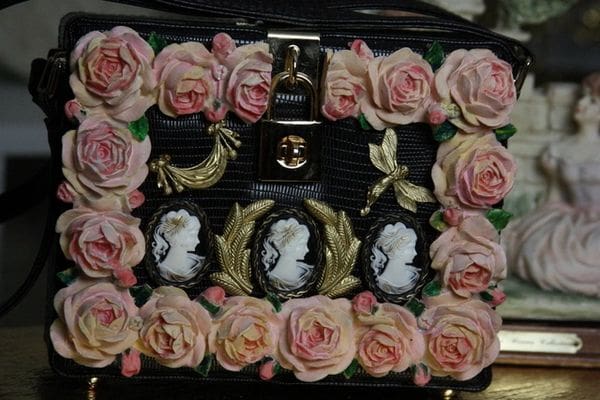A black box with pink roses and gold leaves around it.