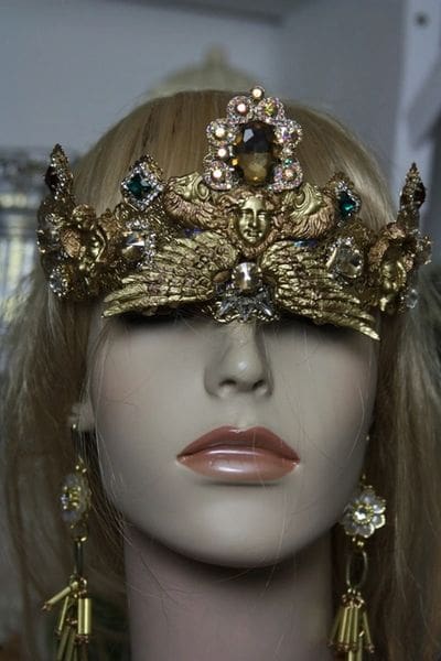 A mannequin wearing a gold crown and earrings.