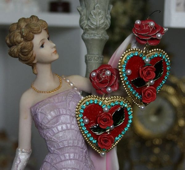 A woman in pink dress holding two hearts.