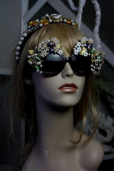 A mannequin wearing sunglasses and headpiece.