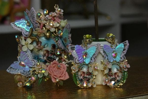 A table with two vases and one vase is decorated with butterflies.