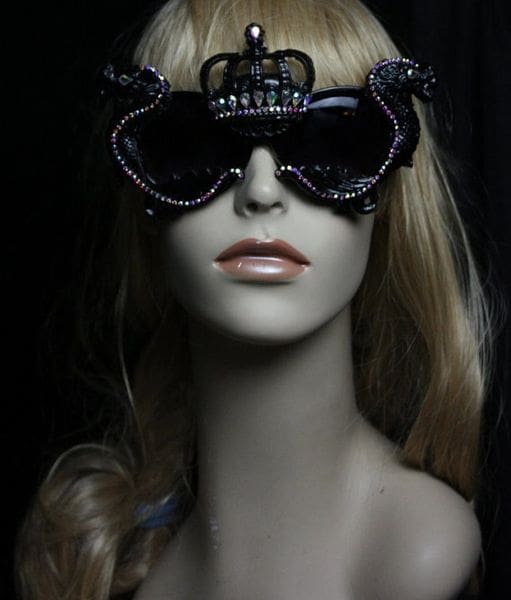 A mannequin wearing sunglasses with a black crown on top of it.