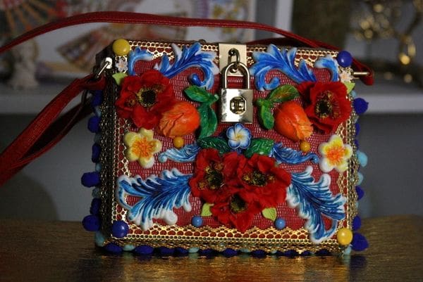 A colorful purse with flowers and leaves on it.