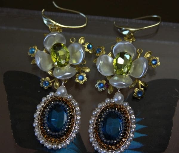 A pair of earrings with pearls and stones.