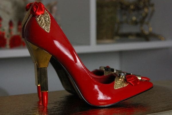 A red high heel shoe with gold leaf on the side.
