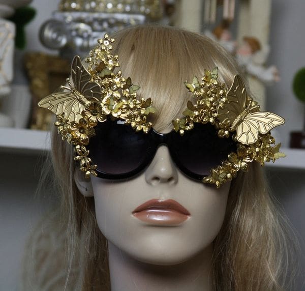 A mannequin wearing gold sunglasses with butterflies on them.