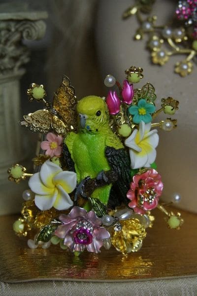 A green statue sitting on top of some flowers.