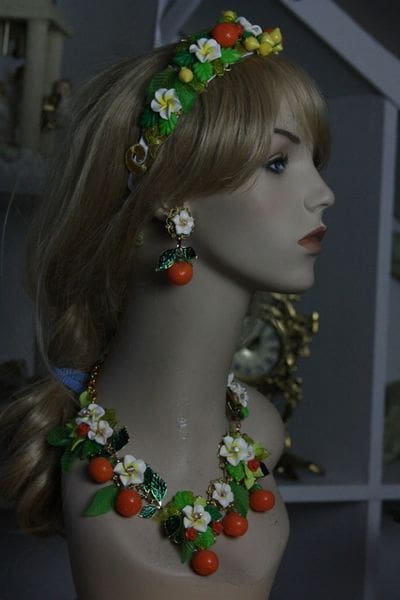 A mannequin wearing jewelry and earrings with oranges.