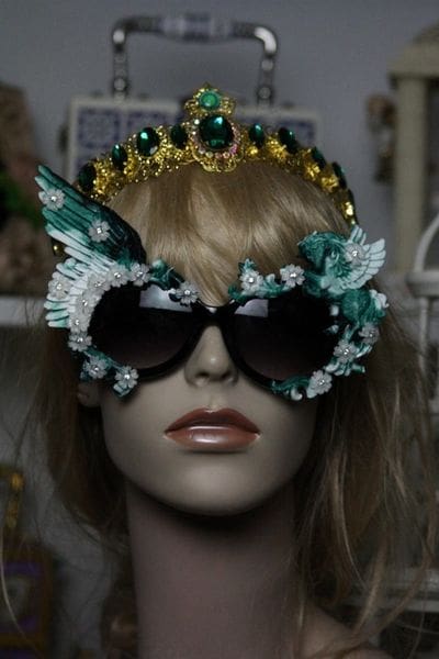 A mannequin wearing sunglasses and a crown.