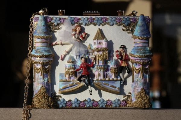 A picture of the back of a purse with a castle and princess theme.